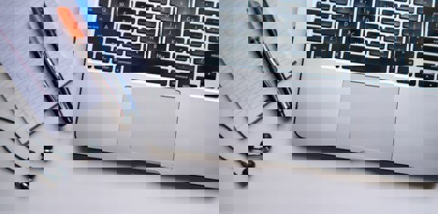 Laptop met daarnaast notitieblok en pennen